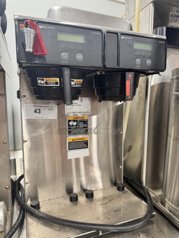 BUNN AXIOM Dual Coffee Brewer, 120V, model with two brew heads, digital displays, silver finish, good condition, visible power cord.