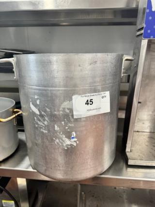 14x15" Aluminum Stock Pot with visible use marks, sturdy handles. Condition indicated by wear; tag reads "For More Great Auction Visit PCAuctions.com 45 QTY."