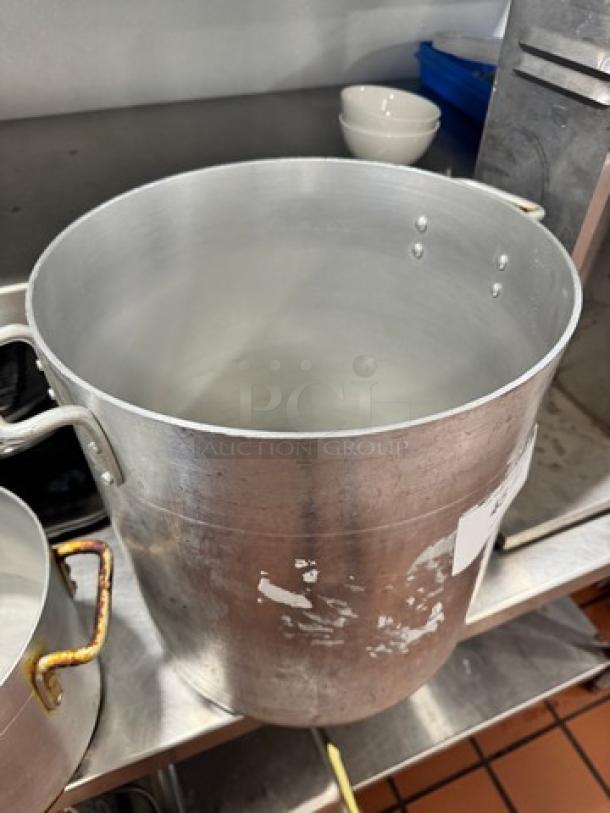 14x15" aluminum stock pot with sturdy handles, showing signs of wear. Ideal for large batch cooking.
