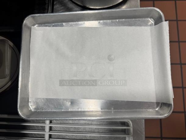 Lot of 9 aluminum pans, each 13x9.5 inches, shown with parchment lining. Suitable for baking, all one money.