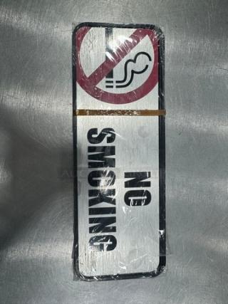 "NO SMOKING" sign, rectangular, white background with bold black text and red crossed-out cigarette symbol, unused condition.