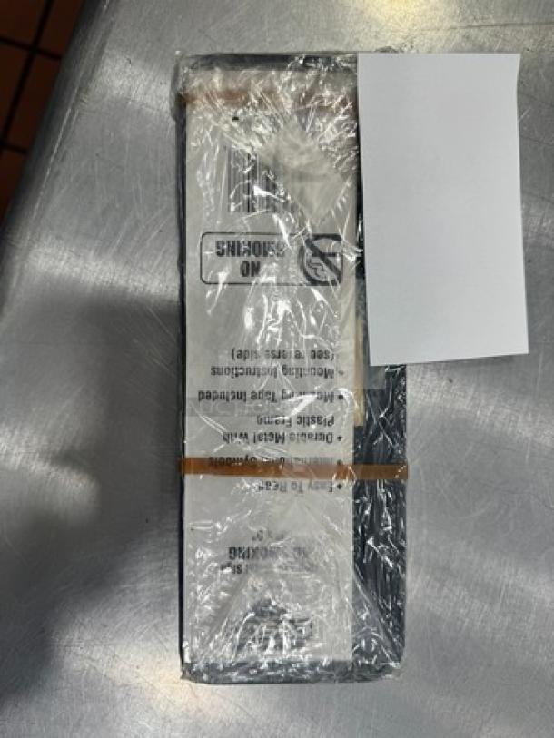 "NO SMOKING" sign, packaged in clear plastic wrap. Text visible, includes instructions. New condition, rectangular shape.
