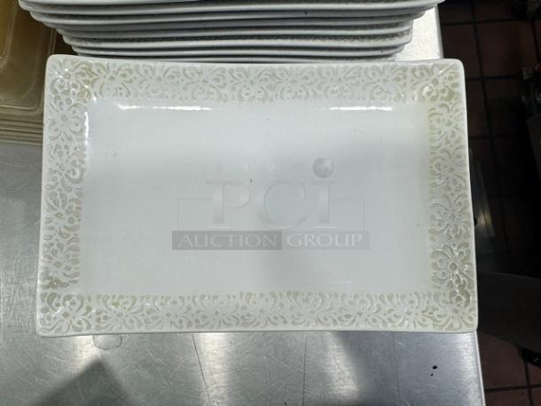 Rectangular porcelain plate BIDX13 with intricate floral border design in mint condition. Stack of similar plates visible.