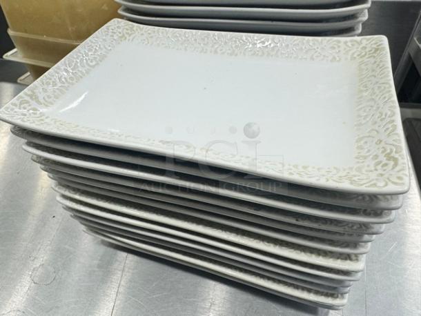 Stack of Rectangular Porcelain Plates BIDX13 featuring an ornate border design, in good condition.