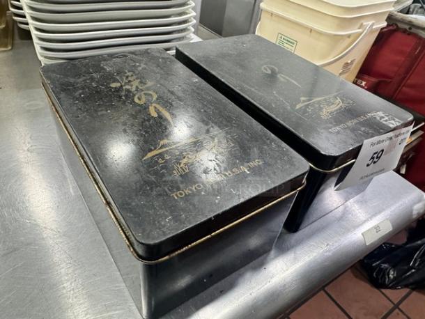 Lot of 2 rectangular black aluminum storage boxes with gold detailing and "TOKYO NUT USA, INC" label. Used condition.