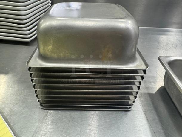 7" stainless steel food pan BIDX12, stack of pans, used condition, slight wear visible, ideal for catering or restaurant use.