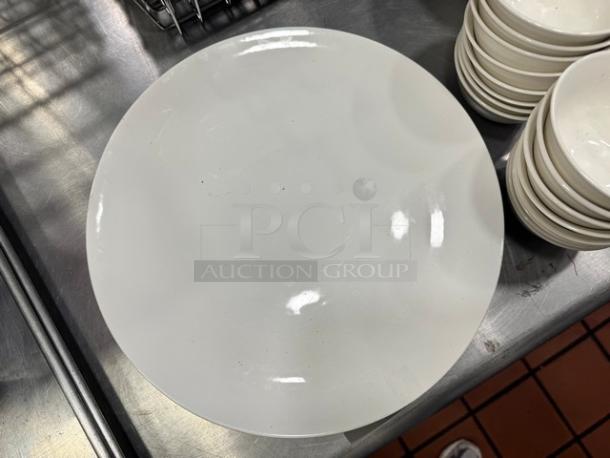 12.5" round porcelain serving platter, BIDX4 model, glossy finish, in good condition on a stainless steel surface.