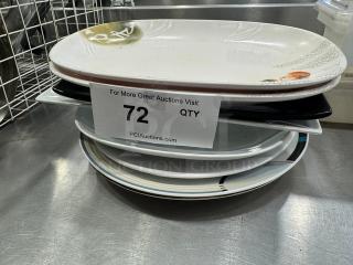 A stack of varied serving platters, some with decorative patterns, labeled "72 QTY" for auction.