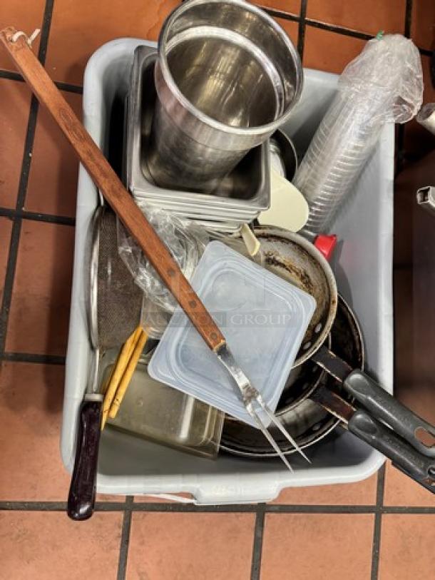 Assorted kitchenware set in a bin, includes metal pots, plastic containers, kitchen utensils, and baking trays.