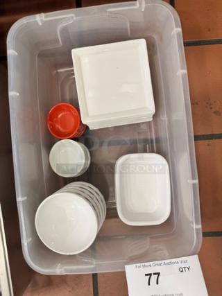 Assorted kitchenware set including white bowls, plates, and red ramekins in a clear plastic container. Good condition.