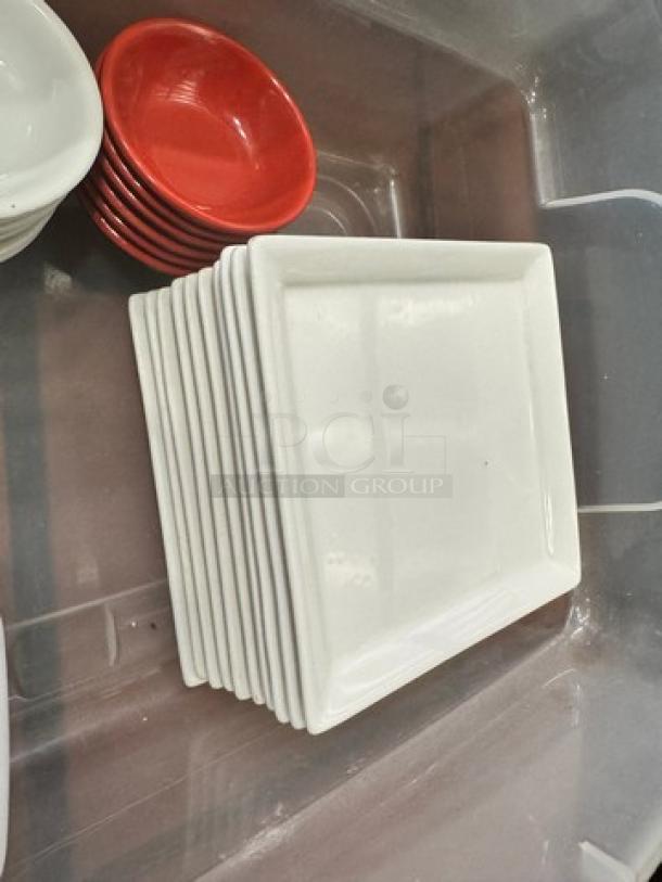 Stack of white rectangular plates and red round bowls, in good condition. Ideal for kitchenware collection.