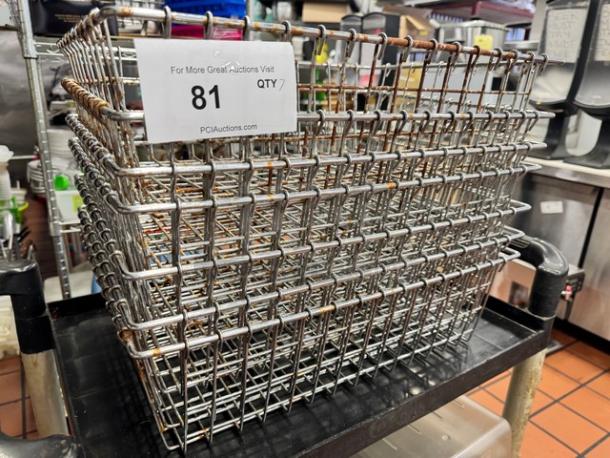 Stack of metal wire baskets on a cart, showing durability. Lot tag number 81 indicates quantity of seven available.
