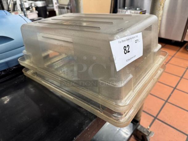 Transparent plastic food storage container with lid, slightly used. Auction tag marked "82" attached.