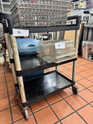 Black multi-tiered bus cart with wheels, metal frame, and labeled bins. Used condition. Ideal for restaurant use.