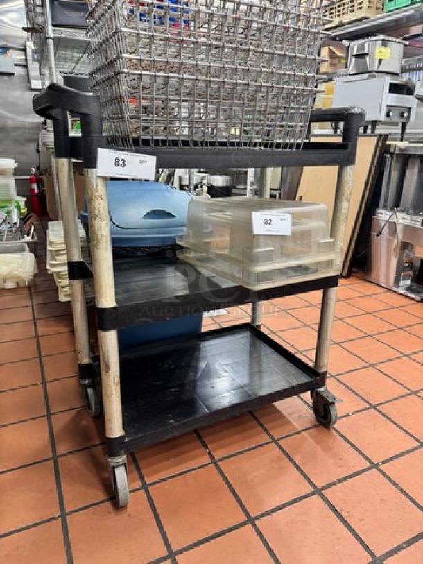 Three-tier bus cart with swivel casters. Black shelves with metal supports. Includes numbered tags, used condition.