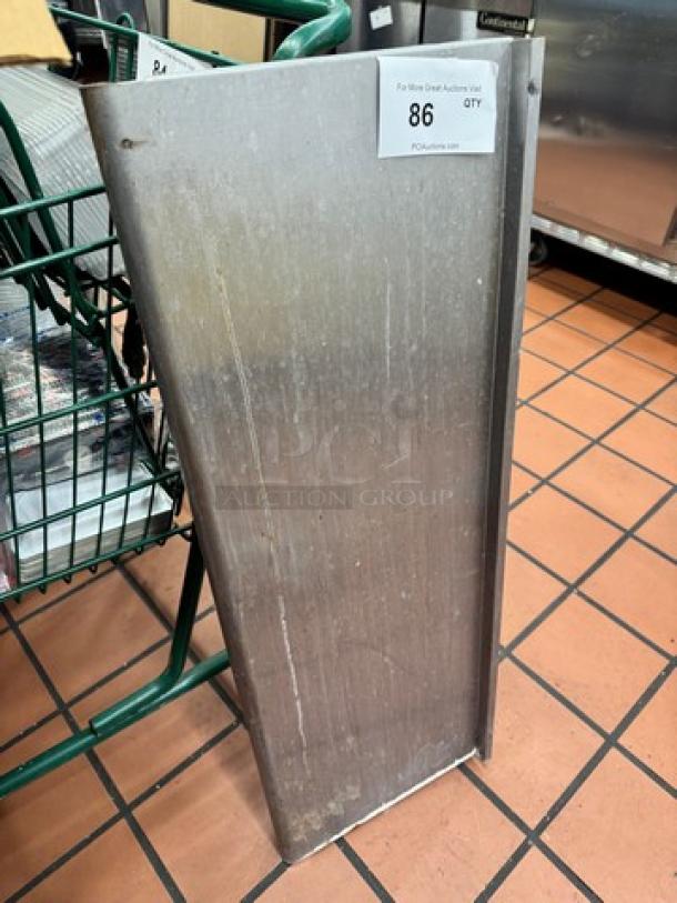 36x12 stainless steel shelf, industrial use, slight surface wear, mounted vertically. Auction tag indicates Lot 86.