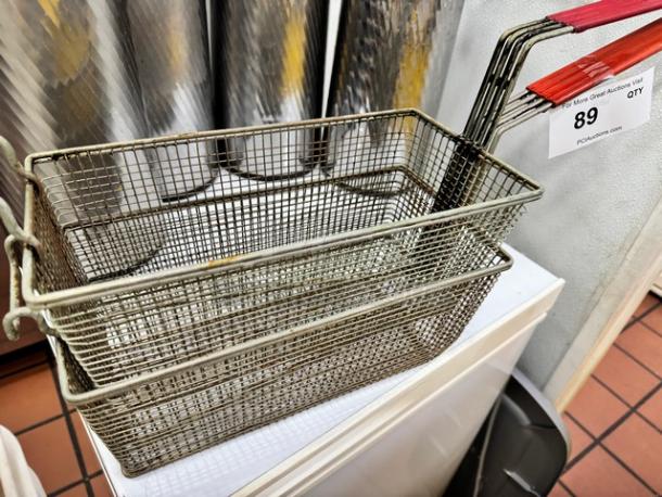 Fryer Basket BIDX2, metal mesh, used condition, red handles, auction tag shows lot number 89.