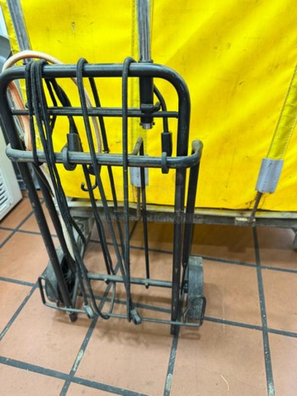 Collapsible rolling utility shopping cart with metal frame, foldable handle, and wheels. Good condition, ideal for easy transport.