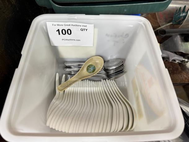 Lot of miscellaneous spoons in a bin; includes metal and ceramic spoons with decorative handle; quantity label reads 100.