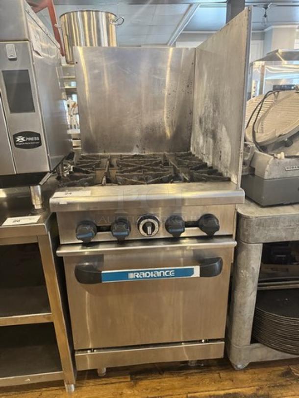 Radiance natural gas 4-burner stove with oven, on legs, stainless steel, used condition, visible brand label.