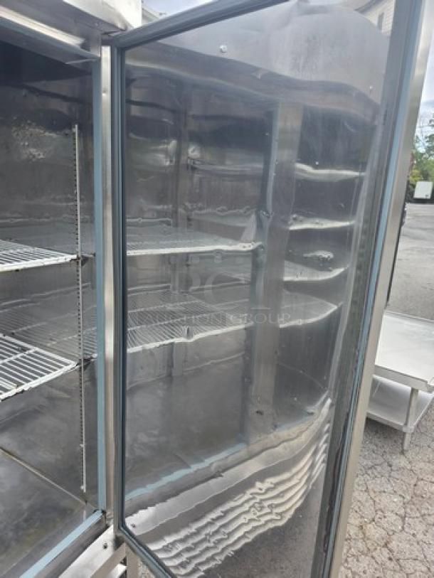 Serv-Ware RR2 two-door stainless steel commercial refrigerator on casters, shelves visible, in good condition.