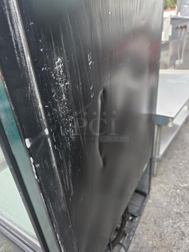 True GDM-26-LD glass door merchandiser, black exterior, dented with scratches, one door, visible wear, model label intact.