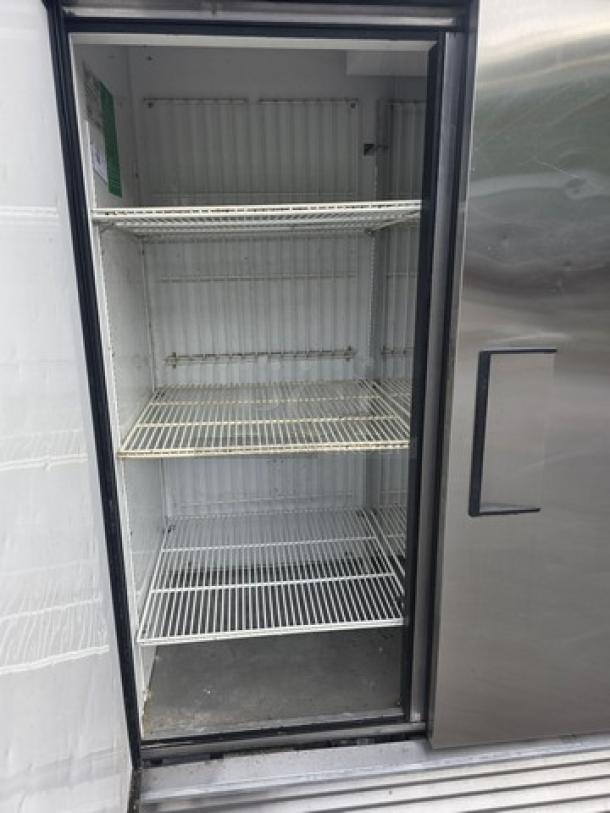 True T-72F T-Series Solid Door Reach-In Freezer, 3 sections, on casters, open door view, wire shelves, stainless steel exterior.