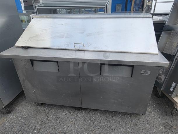 True QA-60-24M-B 60" refrigerated prep table on casters. Stainless steel with dual doors. Visible wear. Ideal for commercial use.