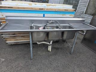 Stainless steel 3 compartment sink, commercial-grade, includes faucets and spray nozzle, used condition, slight surface wear.