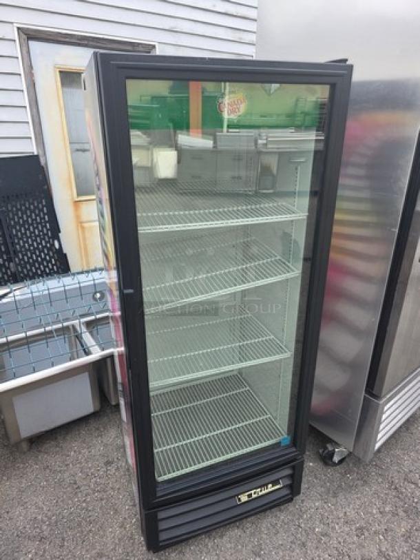 True GDM-12 single swing glass door merchandiser with four wire shelves, black trim, and visible brand logo. Good condition.