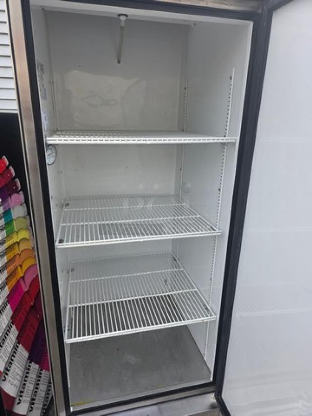 True T-23 reach-in refrigerator with solid swing door, three wire shelves, and mounted on casters; clean interior.