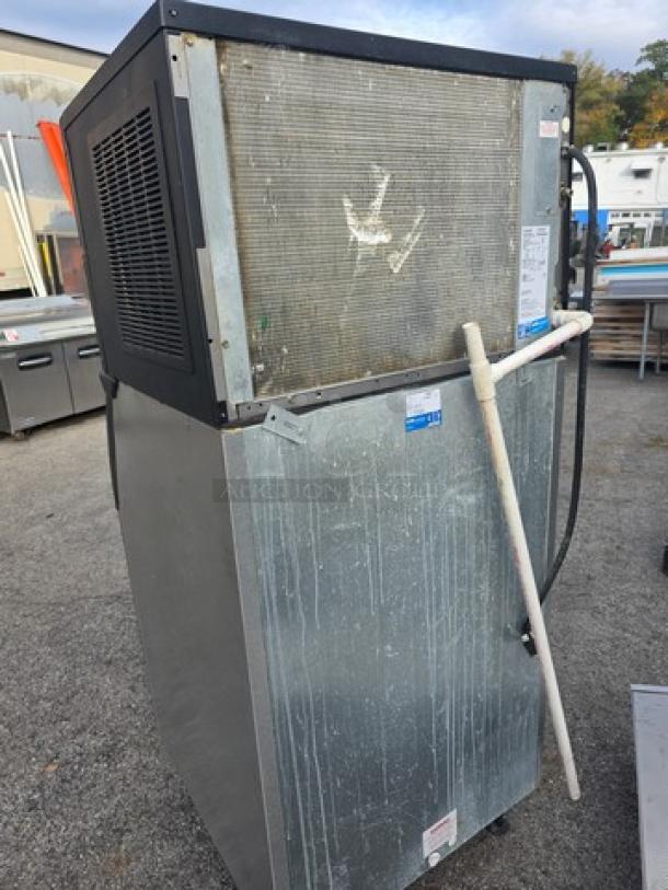 Ice-O-Matic ICE0500HA5 air-cooled ice machine with bin, showing wear. Labels display model info. Suitable for commercial use.