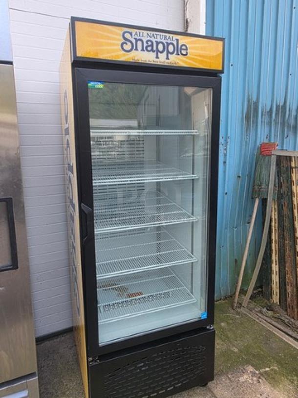 Frigoglass MC750-V2 refrigerator, single glass door, on casters, Snapple branding, five shelves, outdoor setting, good condition.