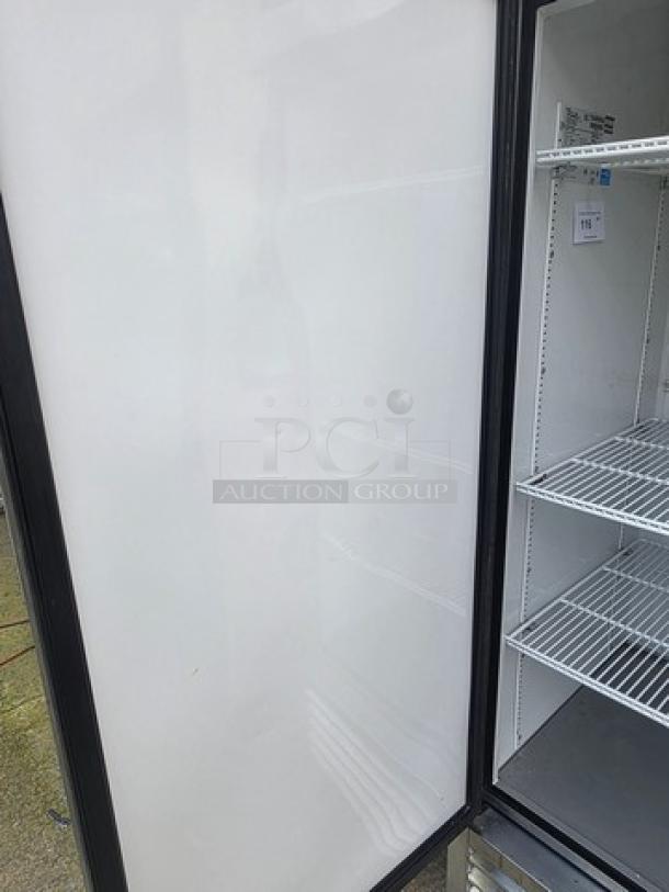 True T-23F reach-in solid swing door freezer on casters, features wire shelves, clean interior, model tag visible.