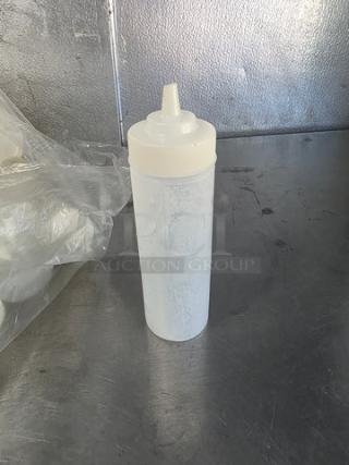 Plastic squeeze bottle, cylindrical, with plastic cap and nozzle, in used condition. Ideal for dispensing liquids.