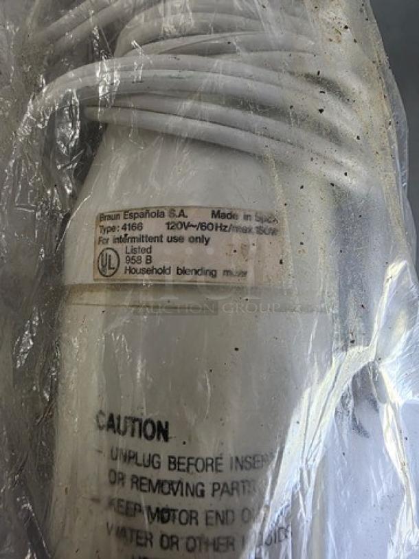 Braun Type 4166 hand-held blender, visible labels indicating model and safety instructions, still in plastic wrap, appears unused.