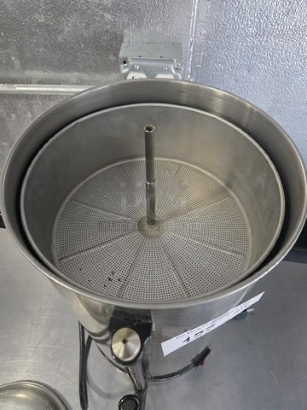 Alfa Coffee Maker CM-110, stainless steel, used condition, top view showing internal filter and spout, industrial setting.