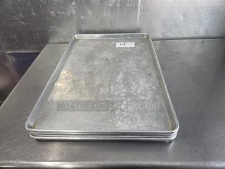 Lot of 4 aluminum baking sheet pans, used condition, visible surface wear. Stackable design, item tagged as "136."