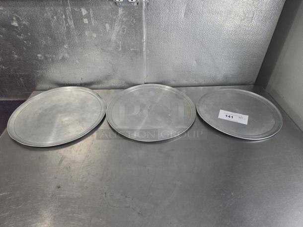 Lot of 3 aluminum pizza trays, in used condition, round shape, with slight surface wear. Label marked "141".