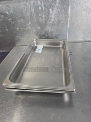 Lot of 4 stainless steel food pans, rectangular, stackable, used condition. Visible label: "204" for identification.