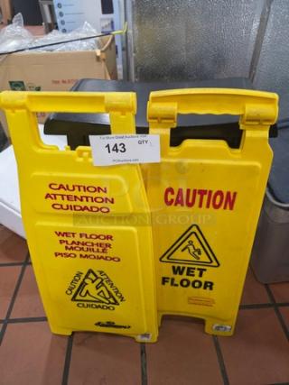 Lot of 2 yellow wet floor signs, bilingual text and slipping icon, used condition, includes auction tag 143.