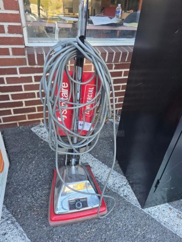Sanitaire Vacuum Cleaner, commercial model, red with chrome base, coiled power cord, minimal wear.
