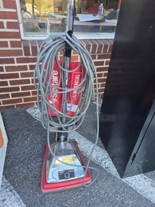 Sanitaire Vacuum Cleaner, commercial model, red with chrome base, coiled power cord, minimal wear.