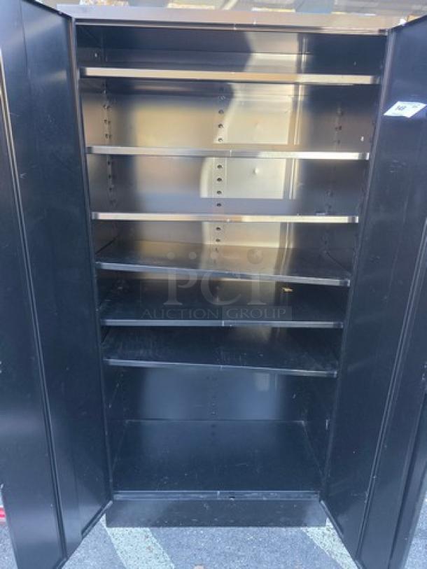 Black metal storage cabinet with five adjustable shelves. Features a double-door design, showing minimal wear, suggesting good condition.