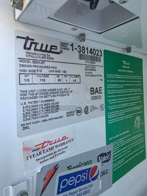 True GDM-07 glass door refrigerated merchandiser; model label; features 2-year lamp warranty and NSF certification.