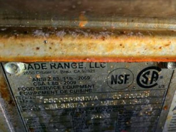 Metal tag on a Jade Range JTRH-24-Titan 24" gas griddle showing model, NSF, and CSA certification details.