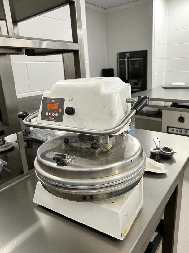 Proluxe DP2010 12" dual-heat dough press, heavy-duty, manual, 208V, 4600W, in a kitchen setting.