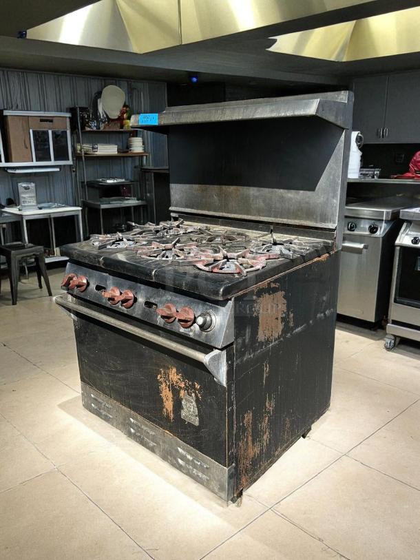 WOLF commercial 6-burner range and oven, natural gas, tested, working, excellent condition; visible wear on exterior.