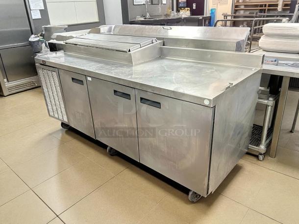 Delfield 85" 3-door pizza prep table in great condition, stainless steel, tested, and working. Features top prep area.