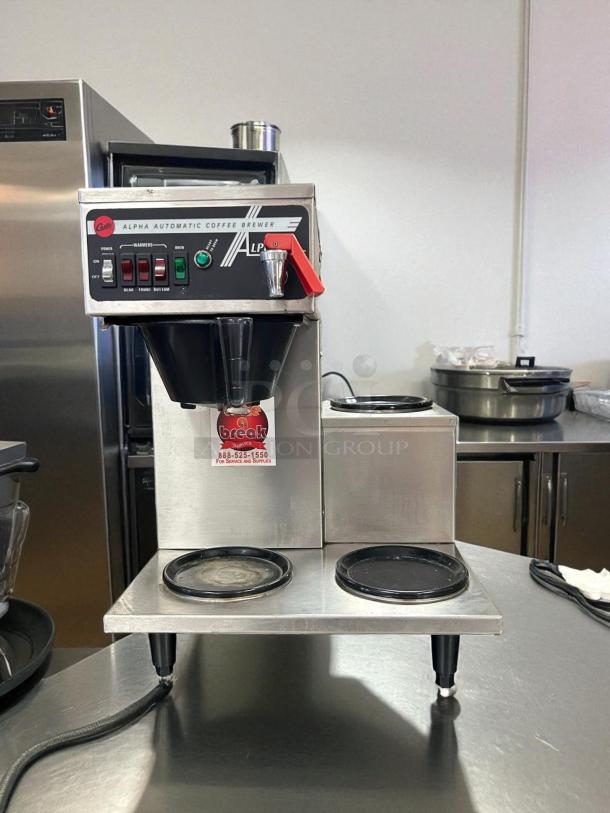Curtis Alpha 3DR coffee brewer with 3 lower warmers, 120/220V. Great condition, tested and working. Power and brew controls visible.